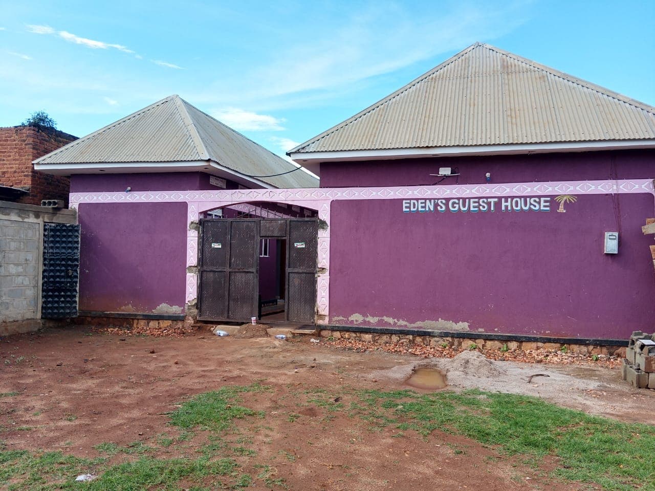 Eden's Guest House frontage with its twin roofs and welcoming gate
