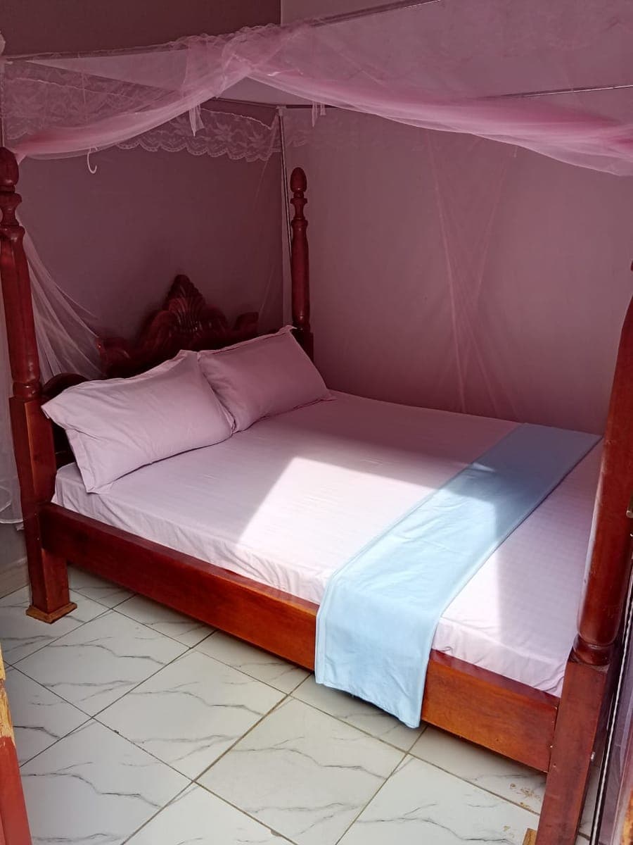 Comfortable room with a pink mosquito net and fresh bedding